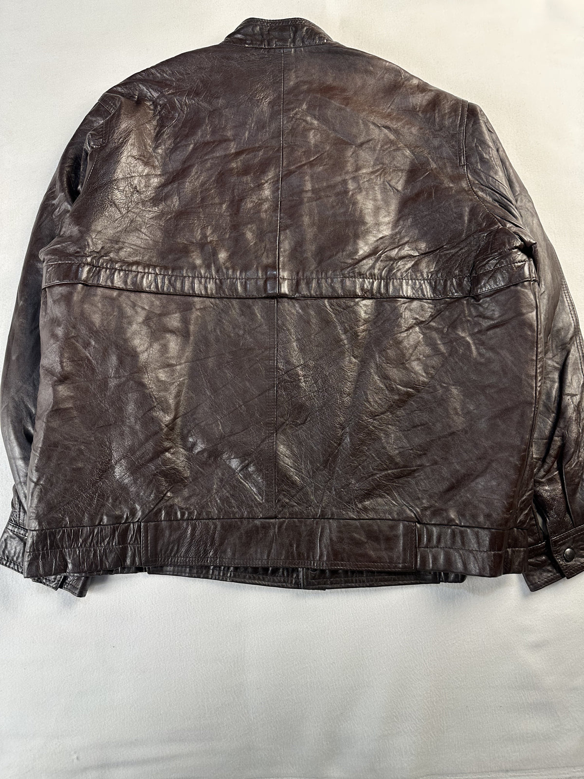 Back of the XL brown cafe racer laid flat with its yoke seam and banded hem