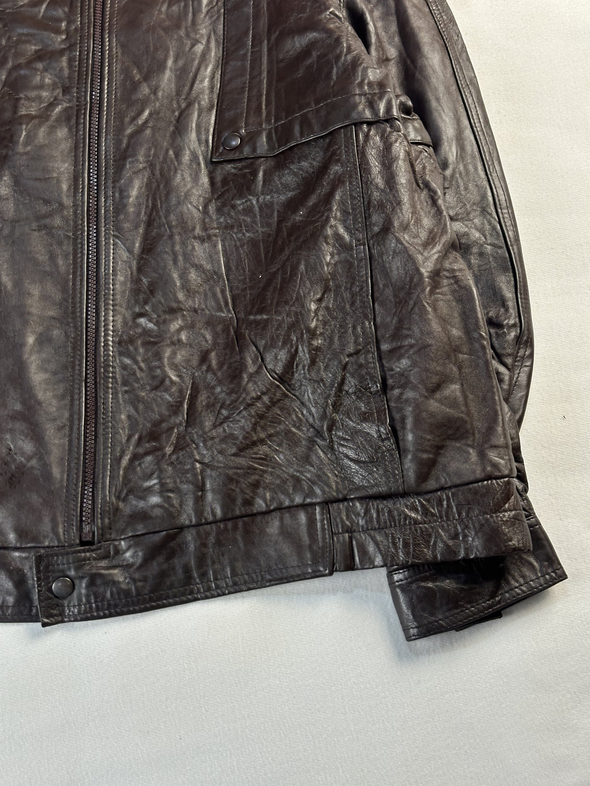 Lower right front showing the pocket flap and the tab fastening at the waist
