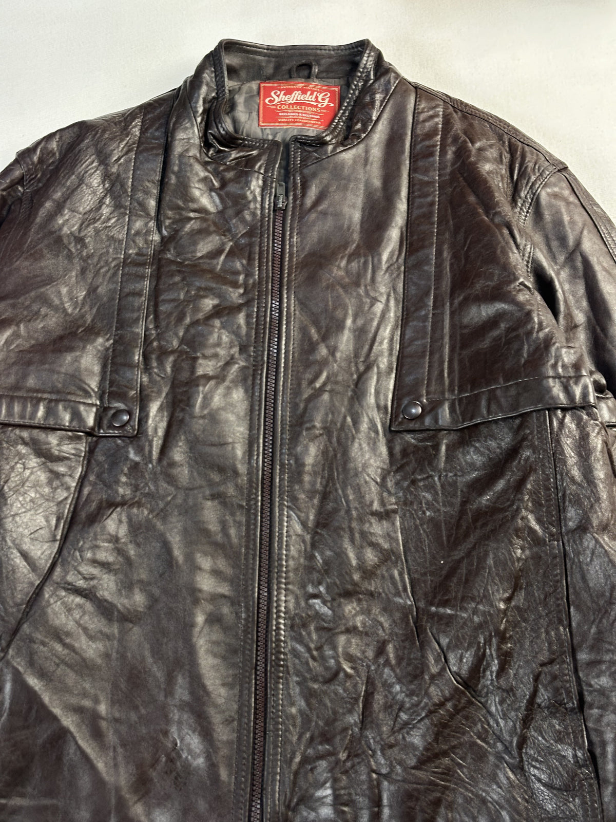 Close view of the band collar and zip at the neck of this vintage brown jacket