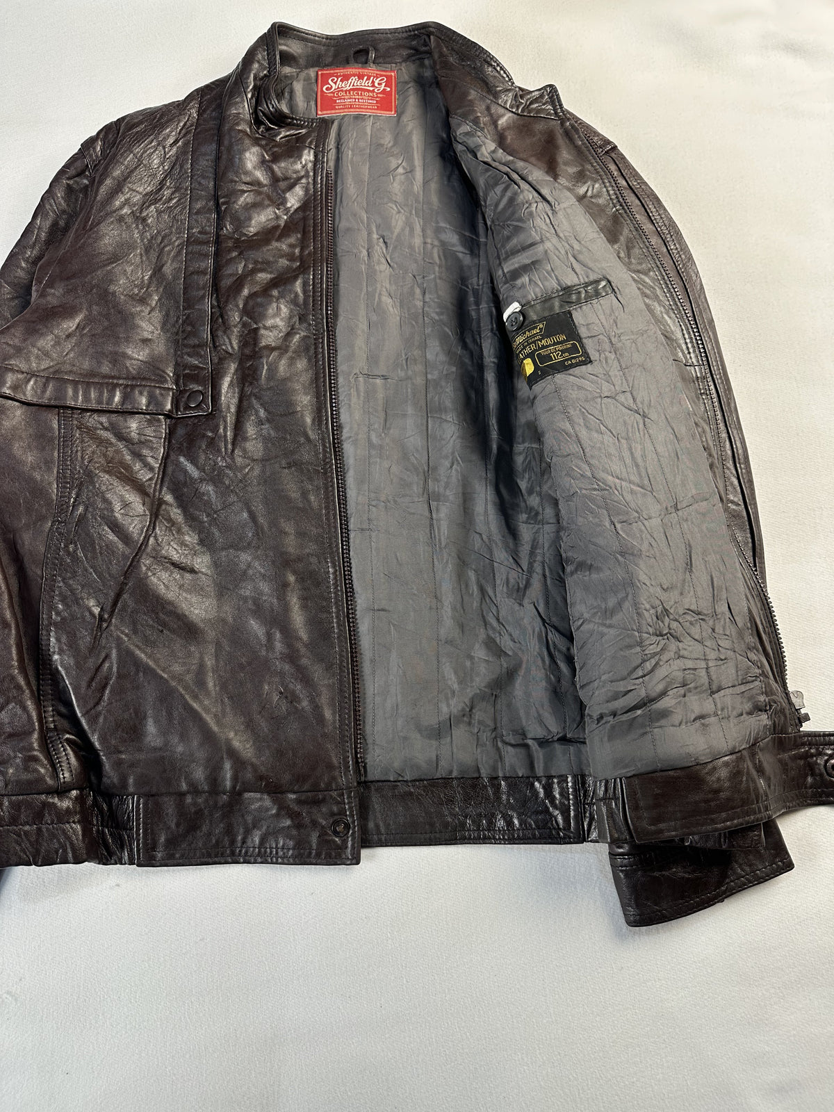 Brown jacket opened out to reveal the full grey lining and inner labelling
