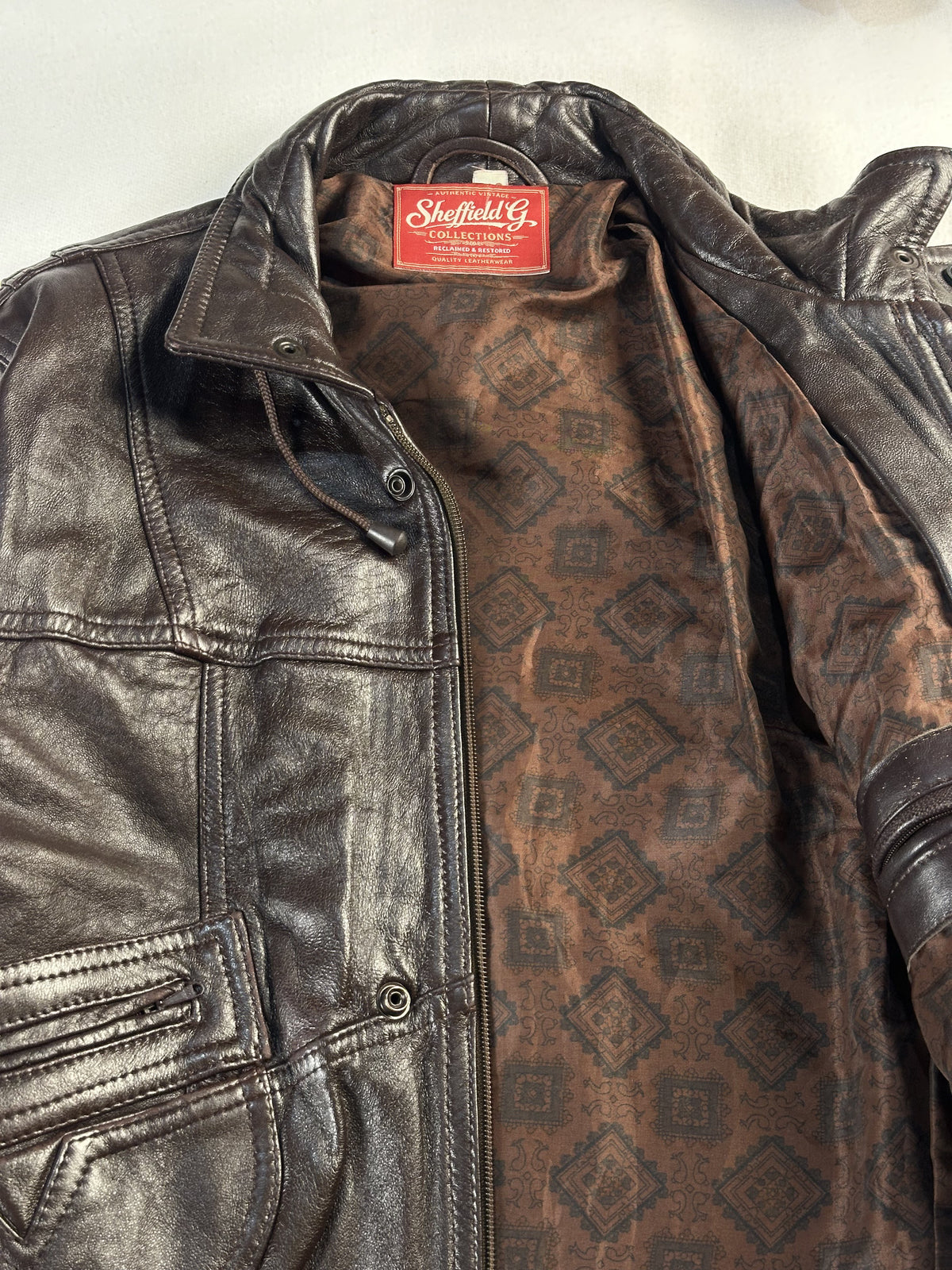 Diamond stitched pockets on this brown leather trucker in size L