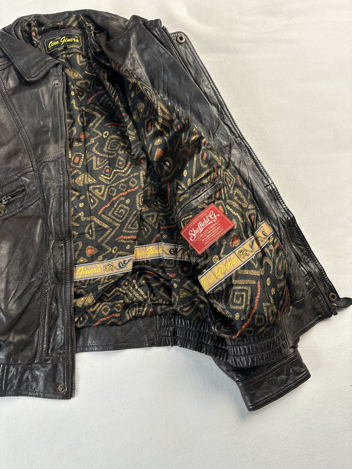 Twin zipped chest pockets on this brown leather harrington in size L