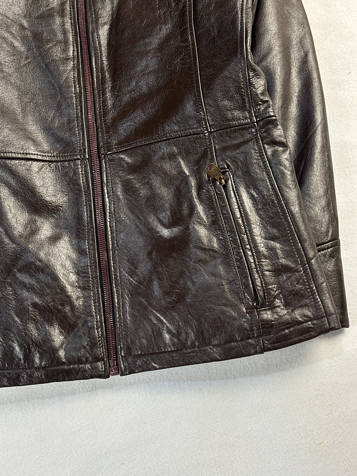 Lower right front where the front zip meets the slanted pocket opening