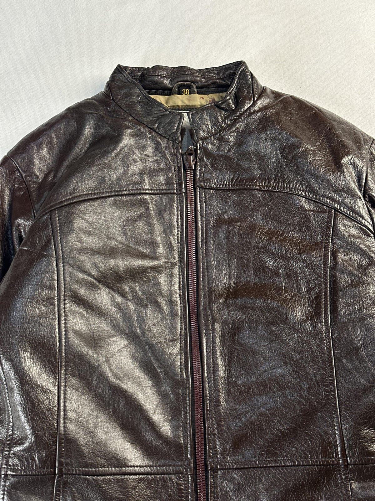 Close view of the stand collar and its throat tab on this vintage brown jacket