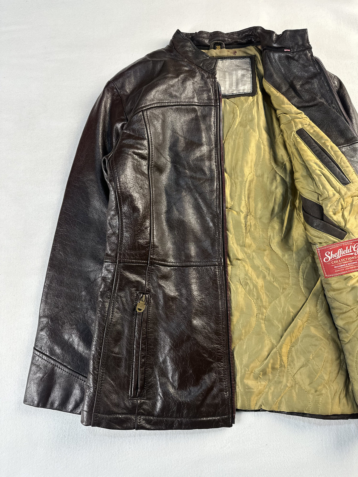Cafe racer laid open to show the full olive quilted lining and inner pocket