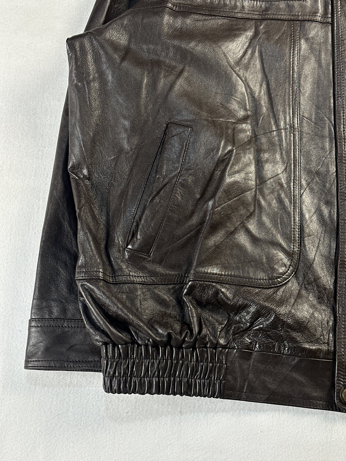 Welt pocket at the left hip with the gathered elasticated hem running below