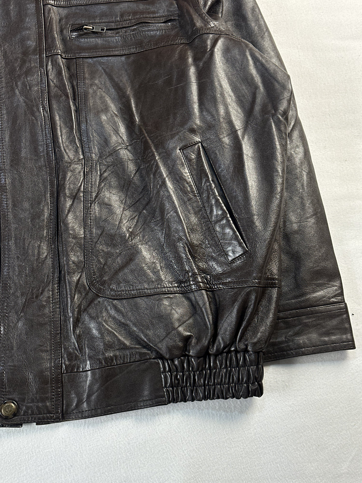 Right side pocket and chest zip above the elasticated hem of the brown jacket