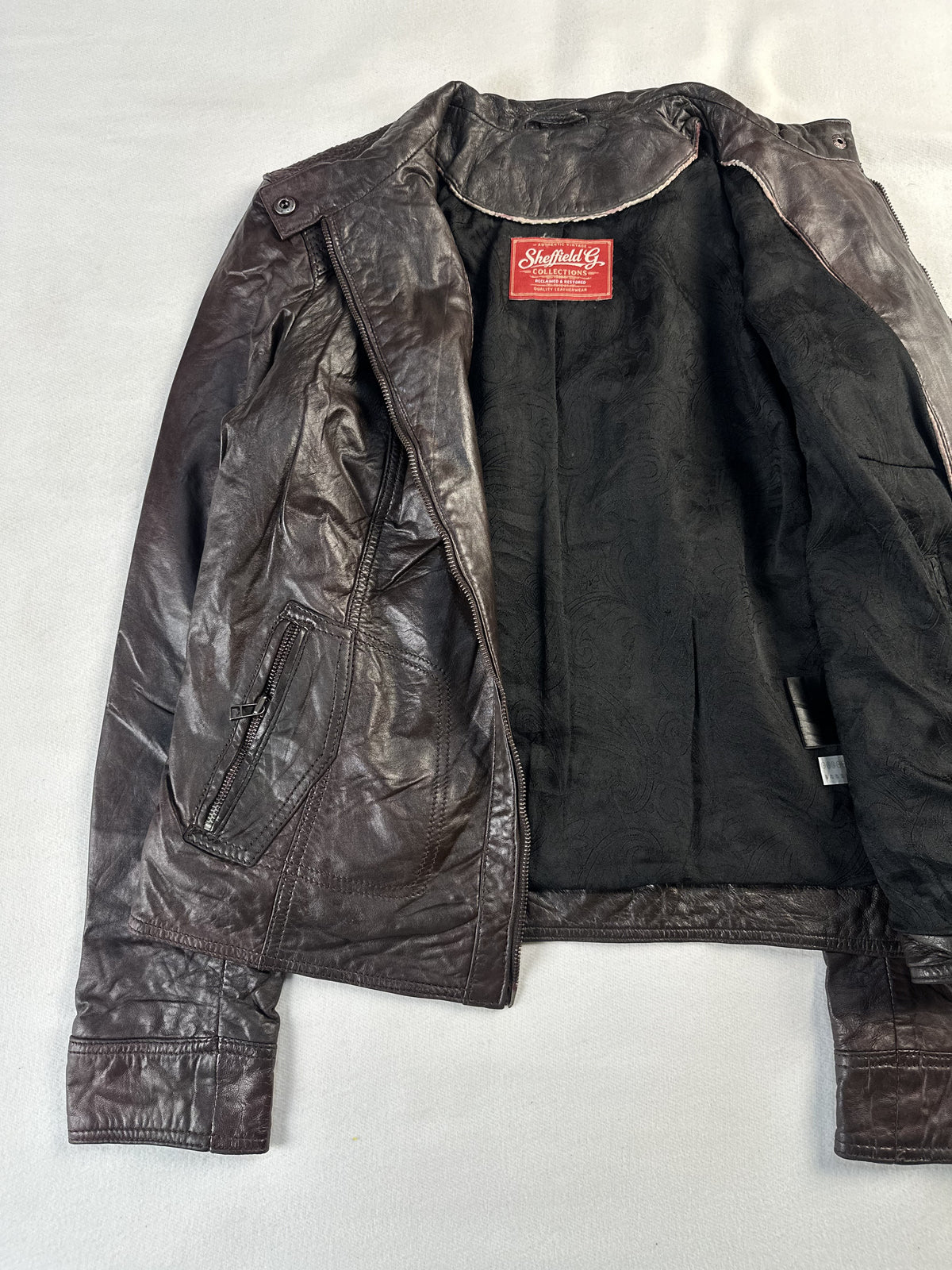 Quilted panelling on this brown leather jacket in size M