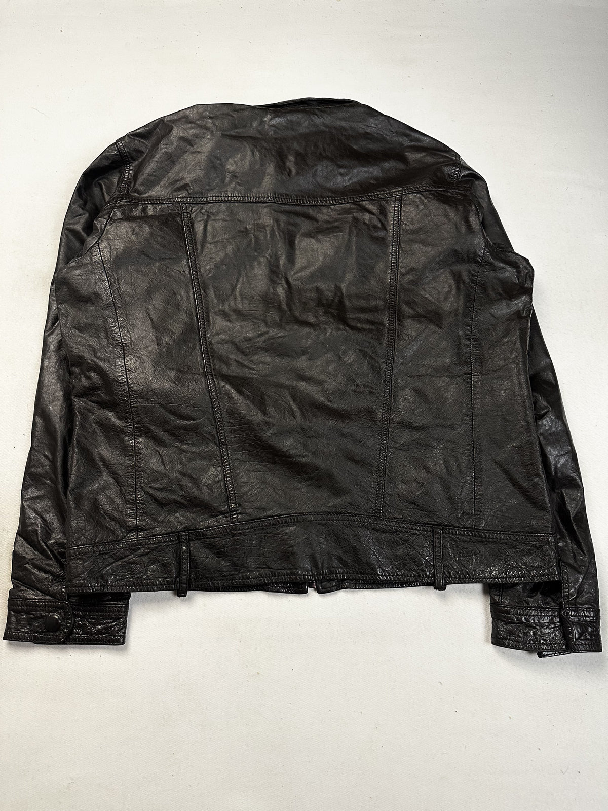 Metal clasp fastening on the front of the brown leather jacket
