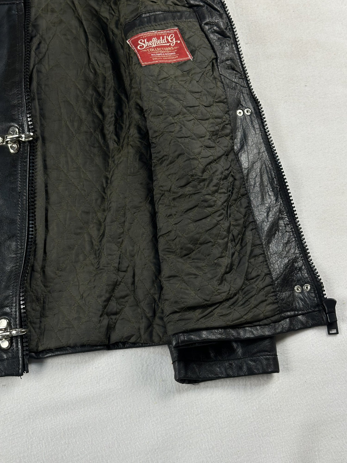 Black leather cafe racer jacket, size M - cuff and hem detail.