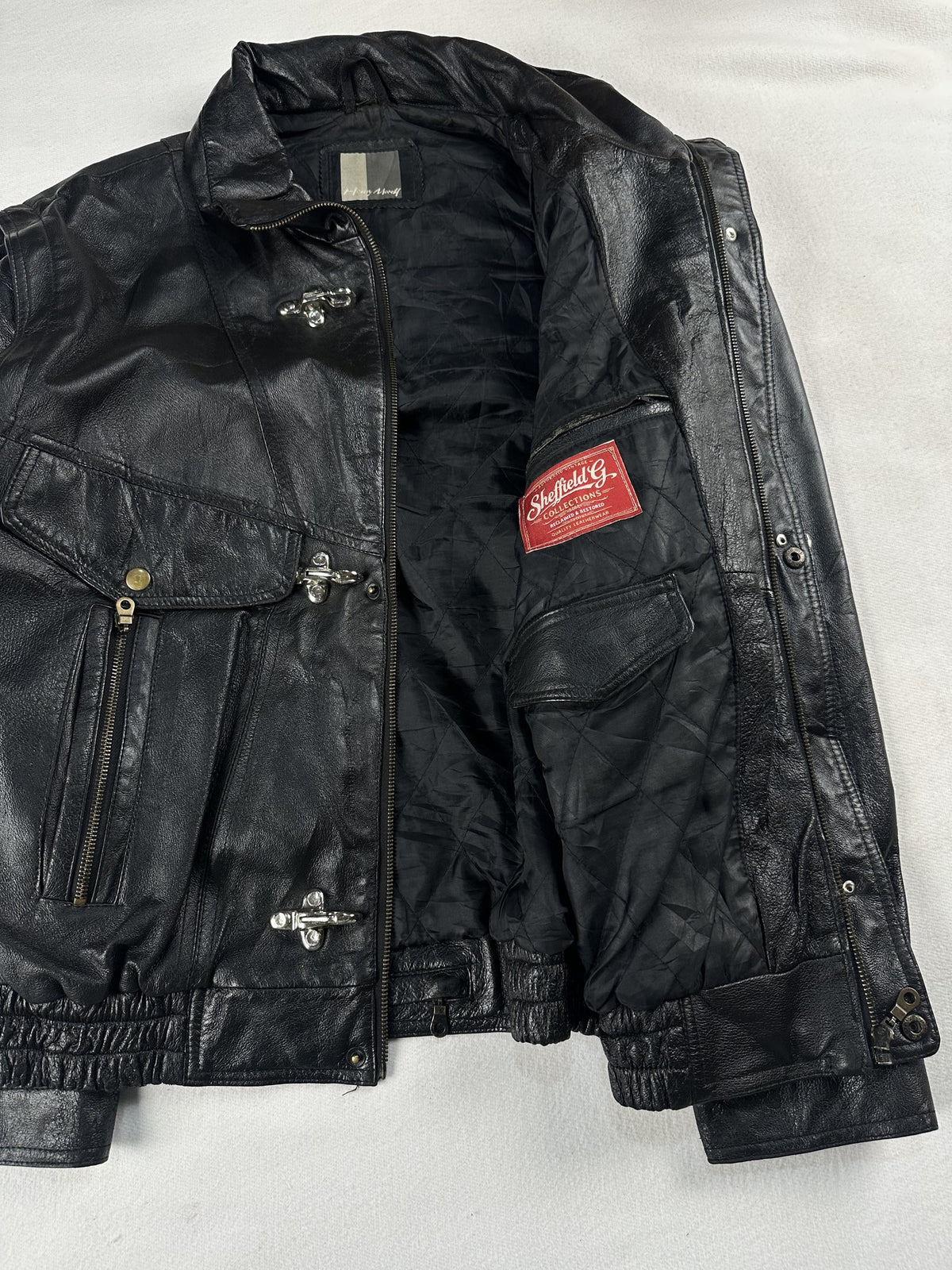 Black leather field jacket, size M - cuff and hem detail.