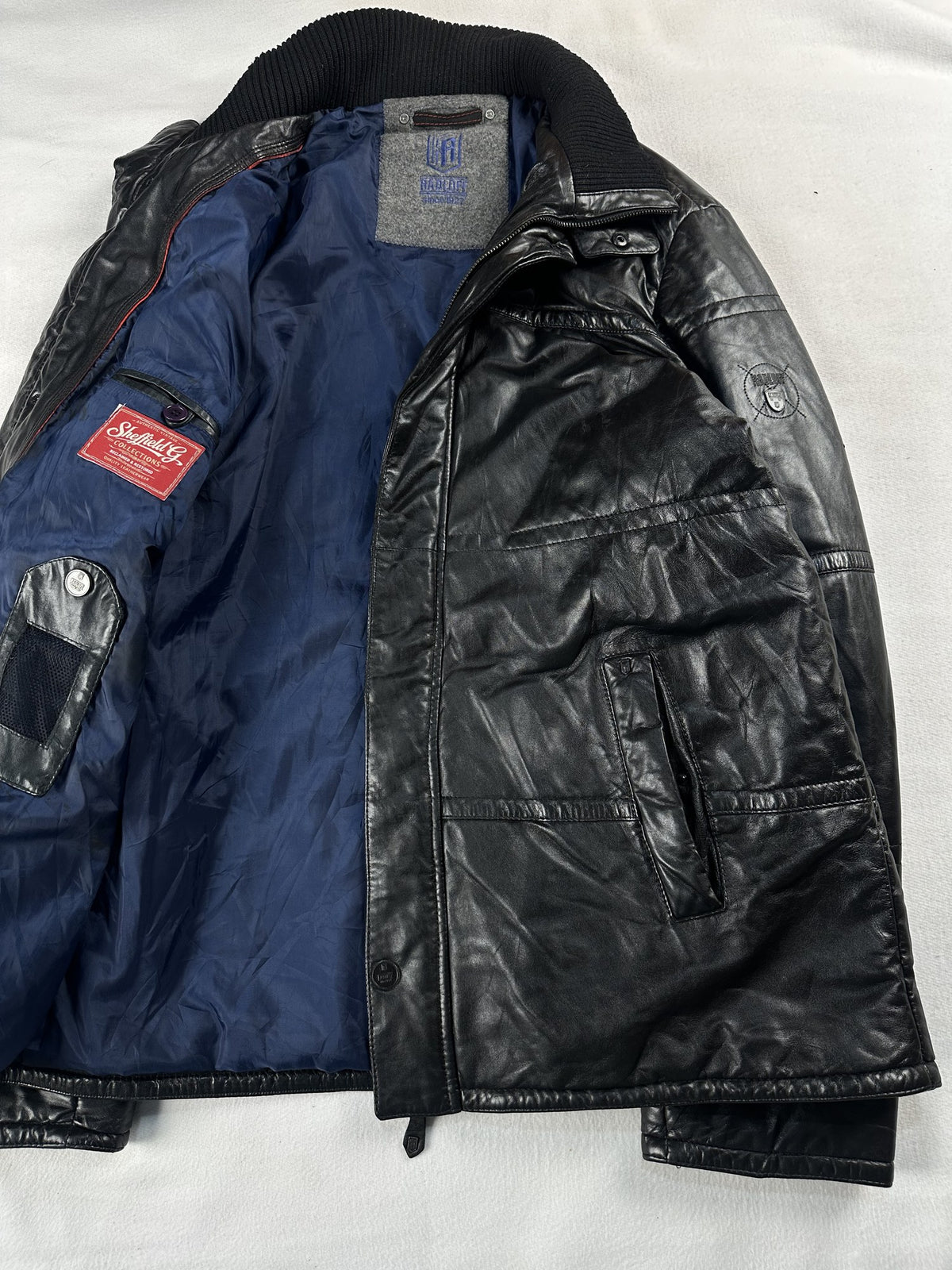 Black leather bomber jacket, size L - cuff and hem detail.
