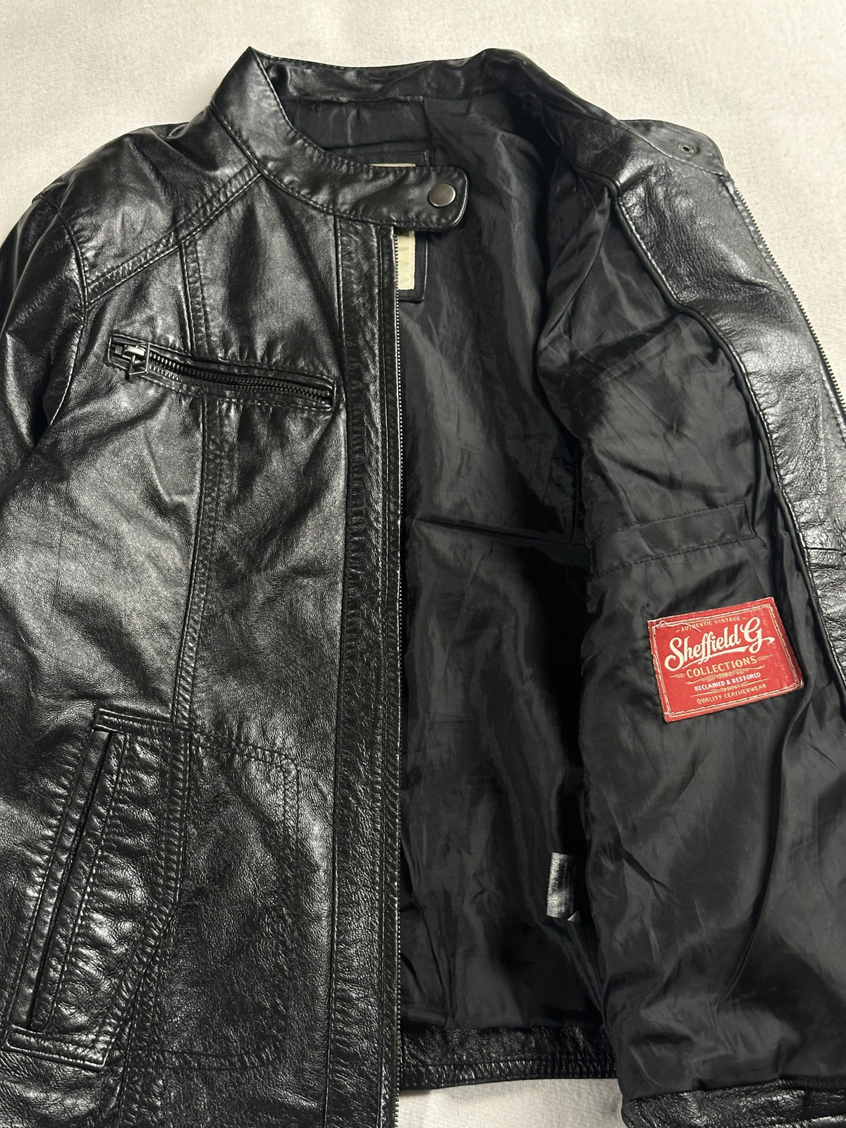 Black leather cafe racer jacket, size XS - cuff and hem detail.