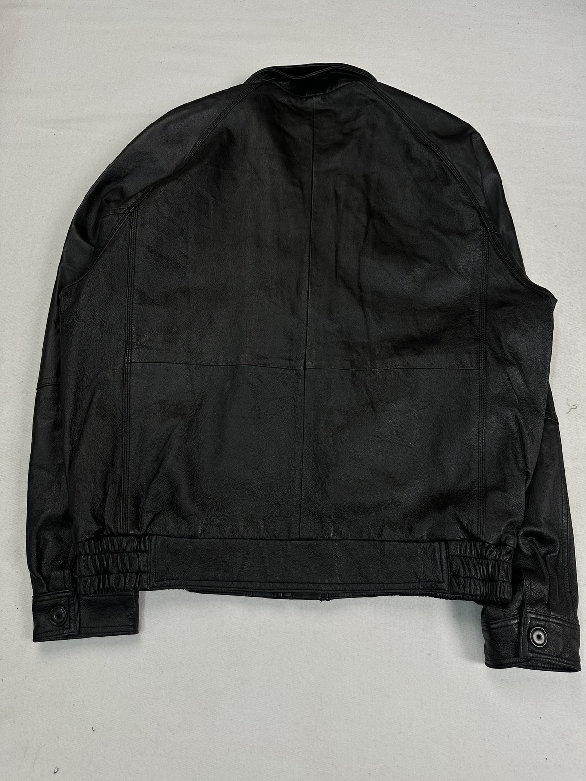 Wide collar sitting open at the neck of the black leather vintage jacket.