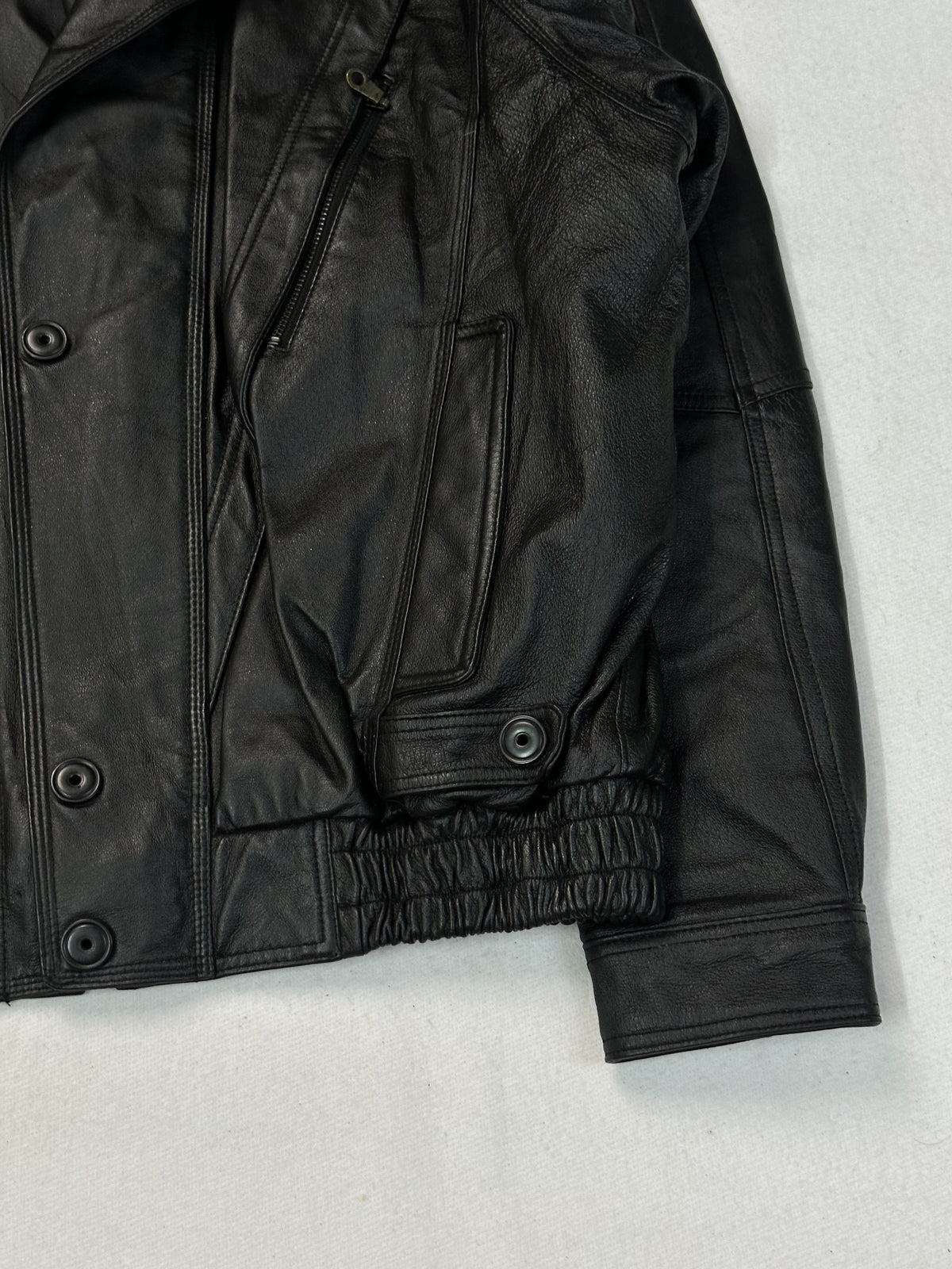 Sleeve of the black leather vintage jacket showing pebbled grain.