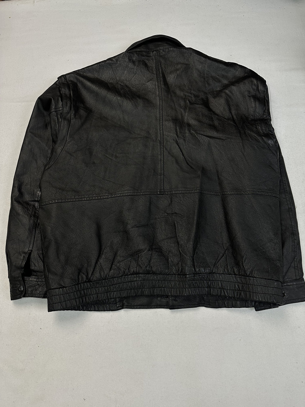 Upper flap pockets on the chest of the black leather field jacket.