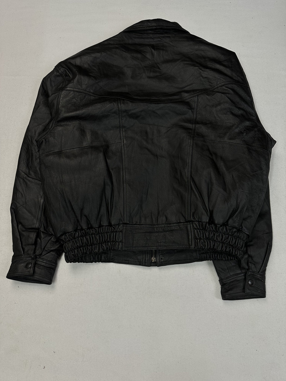 Point collar at the neck of the black leather harrington.