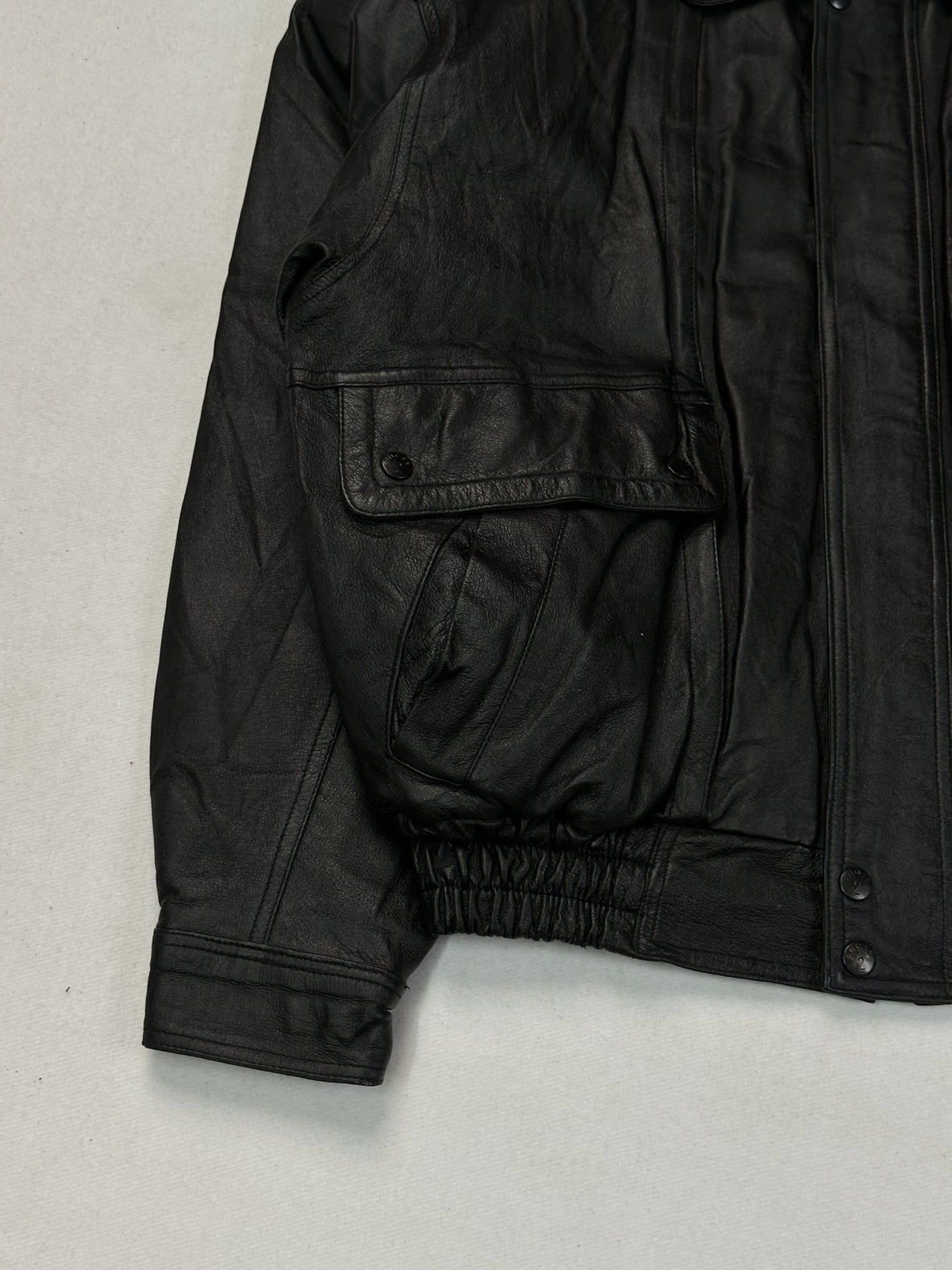 Elastic hem at the waist of the black leather harrington, size M.