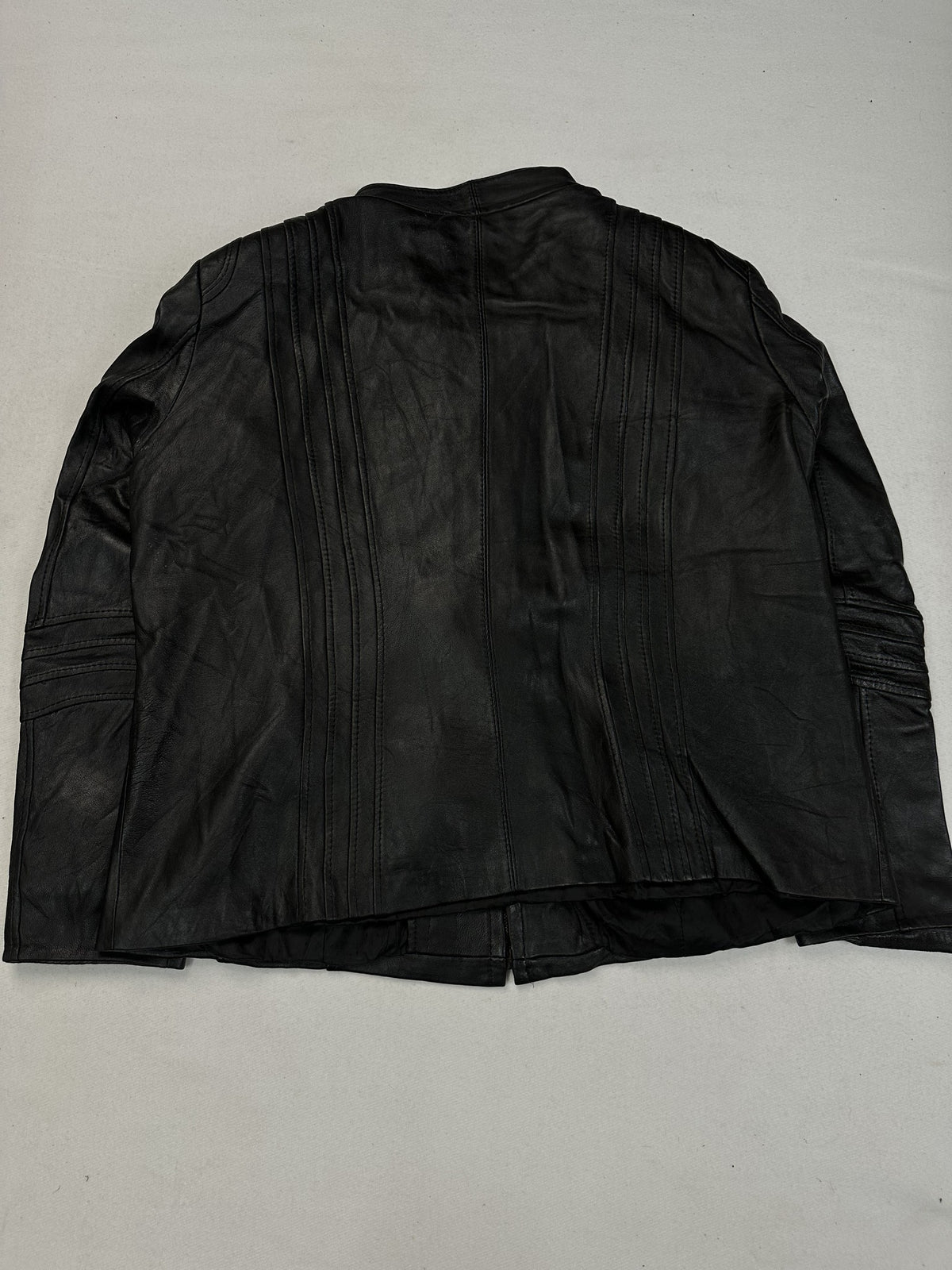 Stand collar at the neck of the black leather cafe racer jacket.