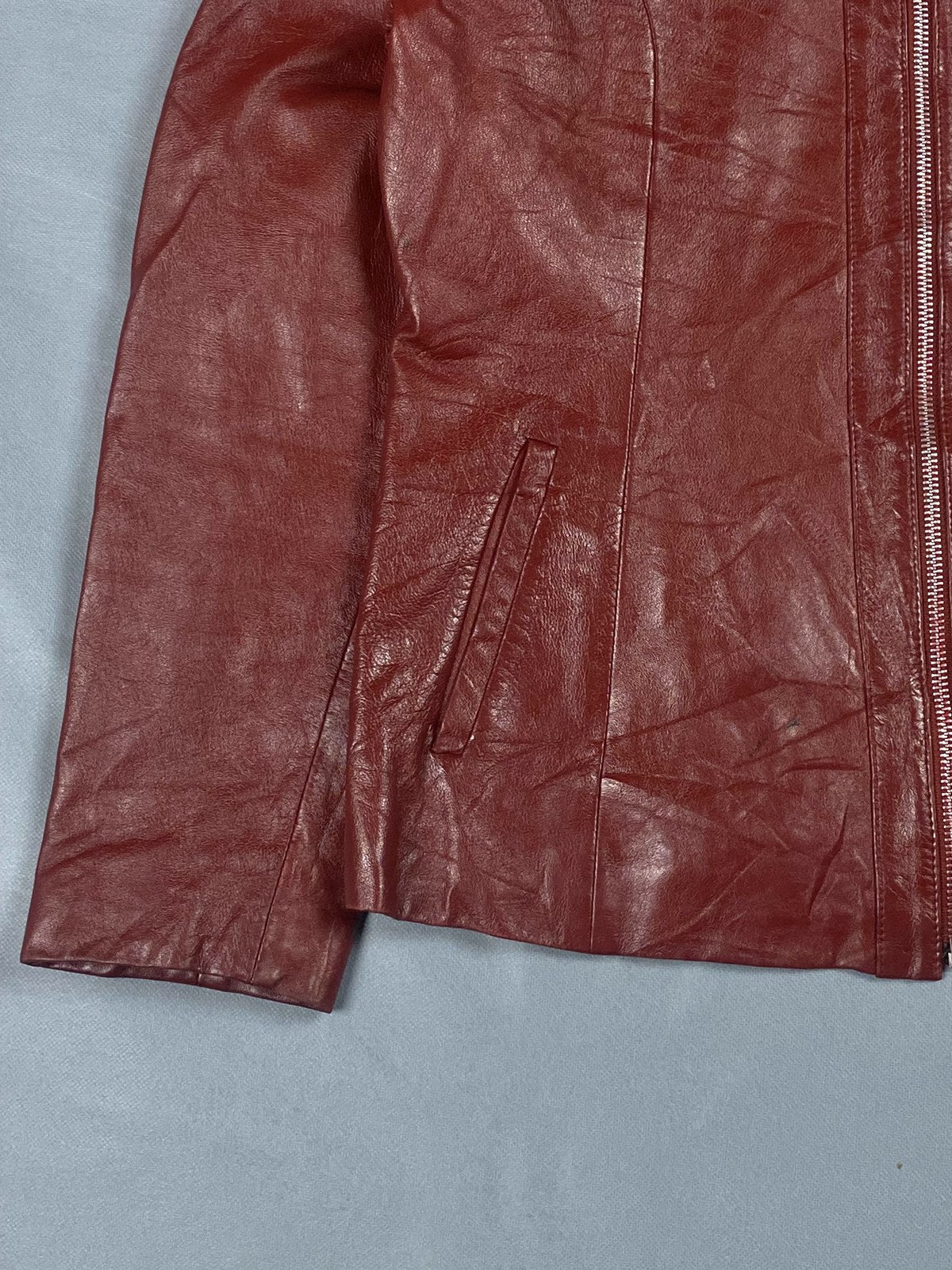 Sleeve and cuff detail of the burgundy leather biker jacket