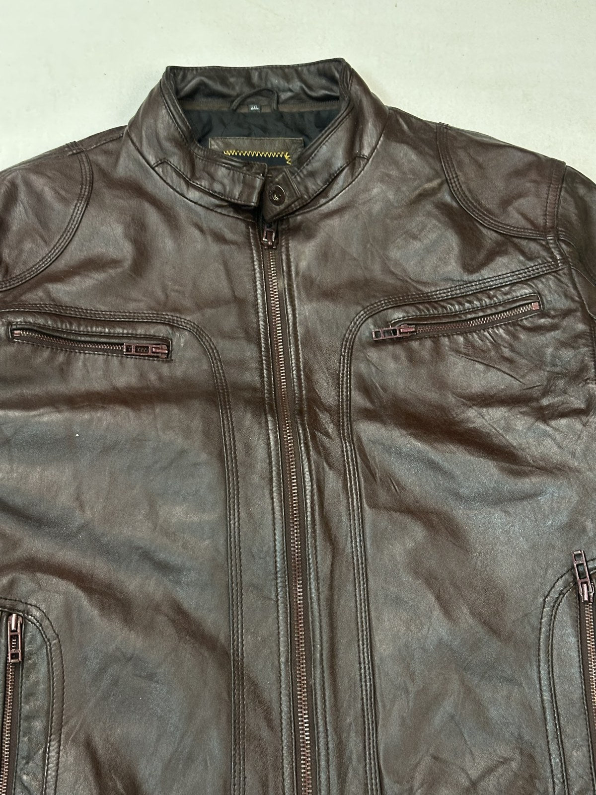 Band collar and neck fastening on the burgundy leather biker jacket