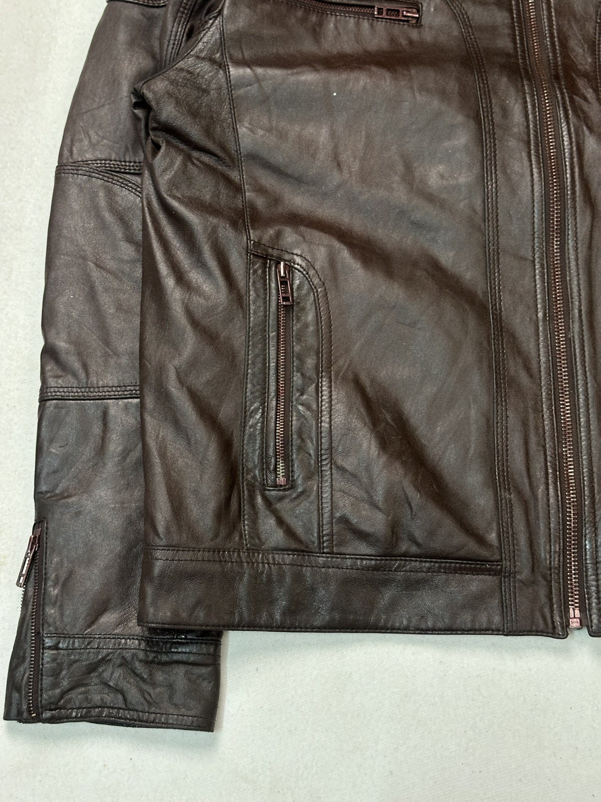 Twin zip pockets on the front of the burgundy leather biker jacket