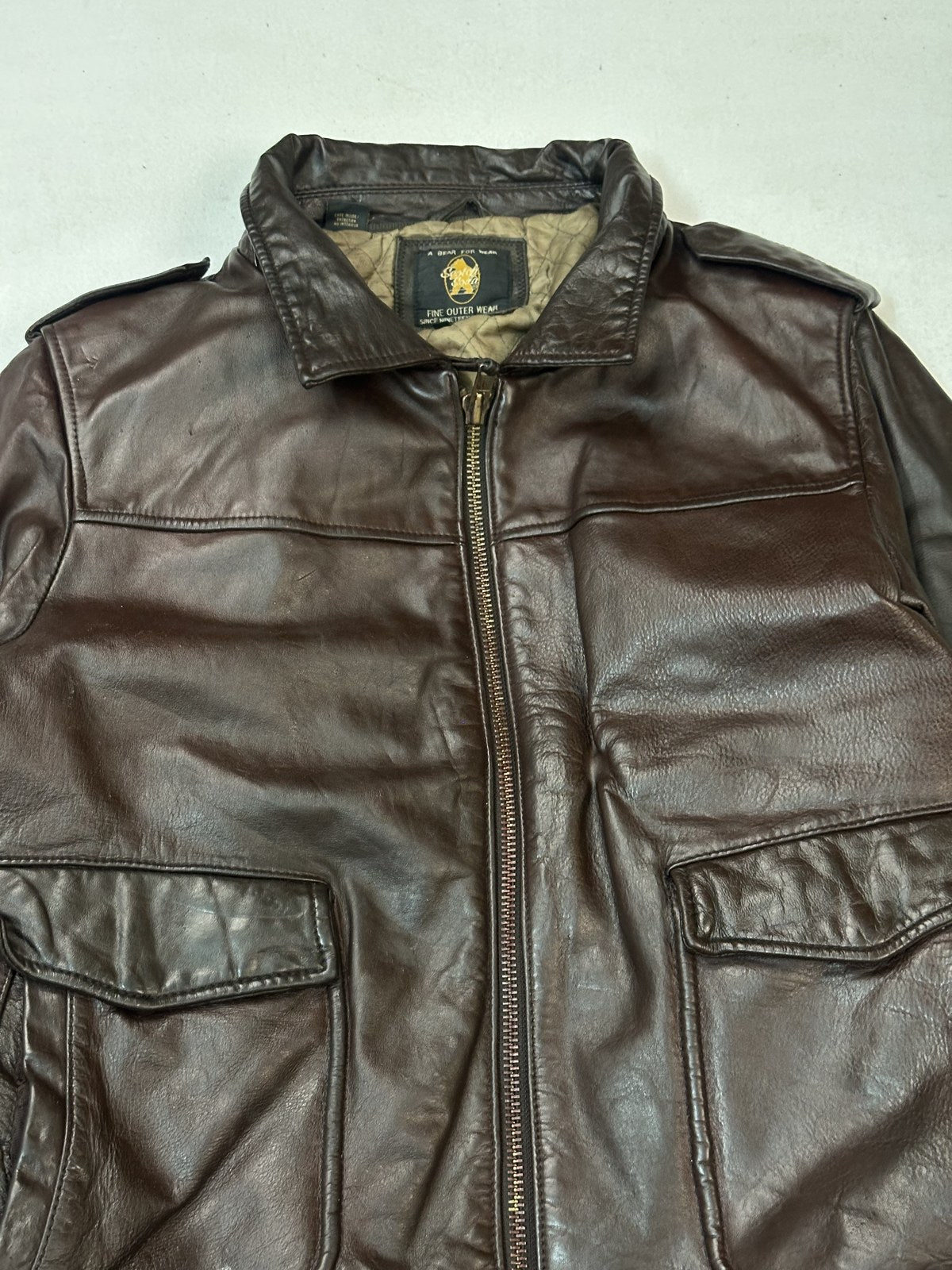 Band collar at the neck of the burgundy leather biker jacket