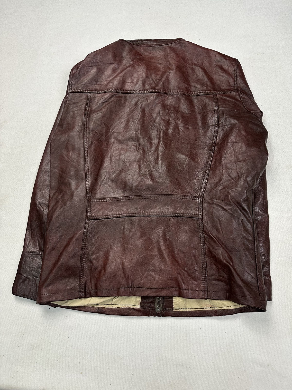 Back of the burgundy biker jacket, showing the plain rear panel and shoulder seams