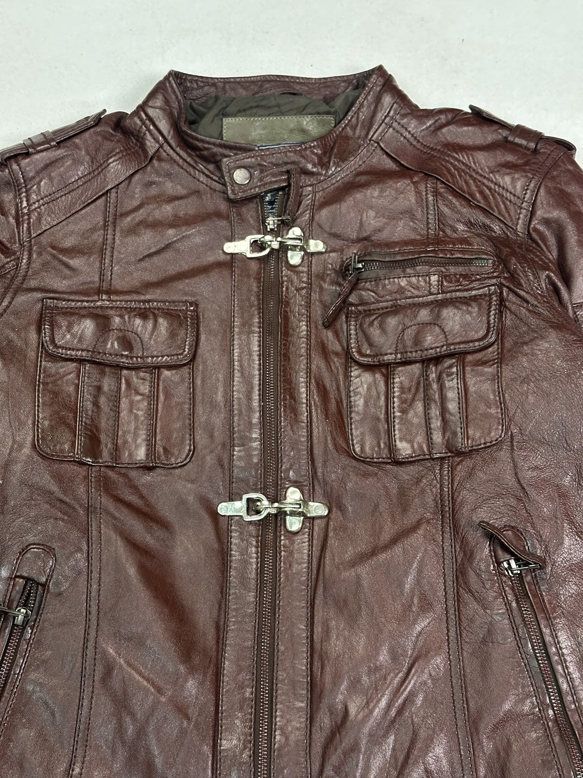 Rear of the clasp fastened burgundy biker jacket, rib visible along the hem
