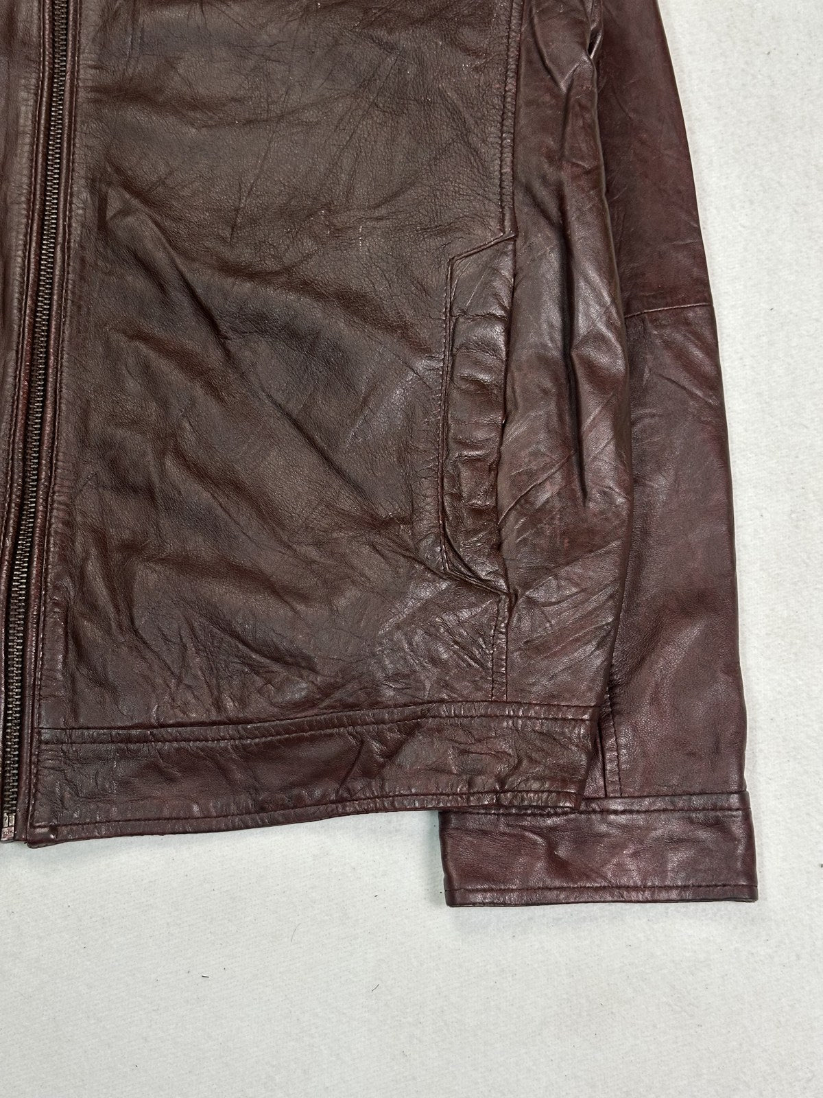 Close view of the band collar and neck fastening on the burgundy biker jacket