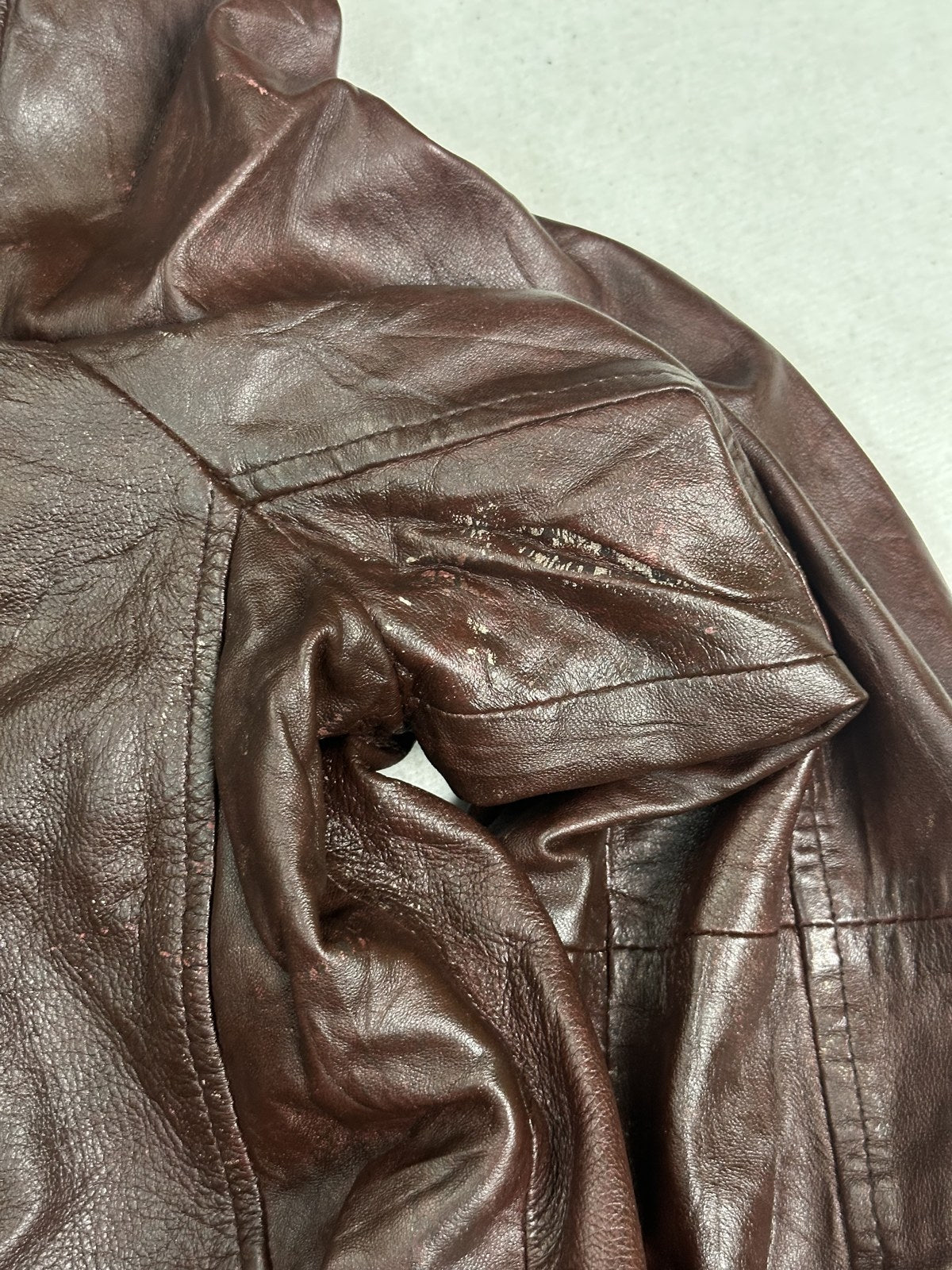 Detail shot of the zip pull and stitching on the XL burgundy biker jacket