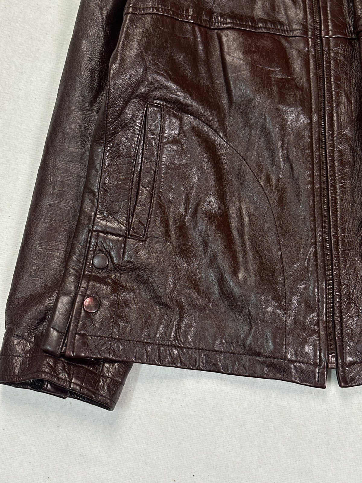 Band collar and twin zip pockets on the compact burgundy biker jacket
