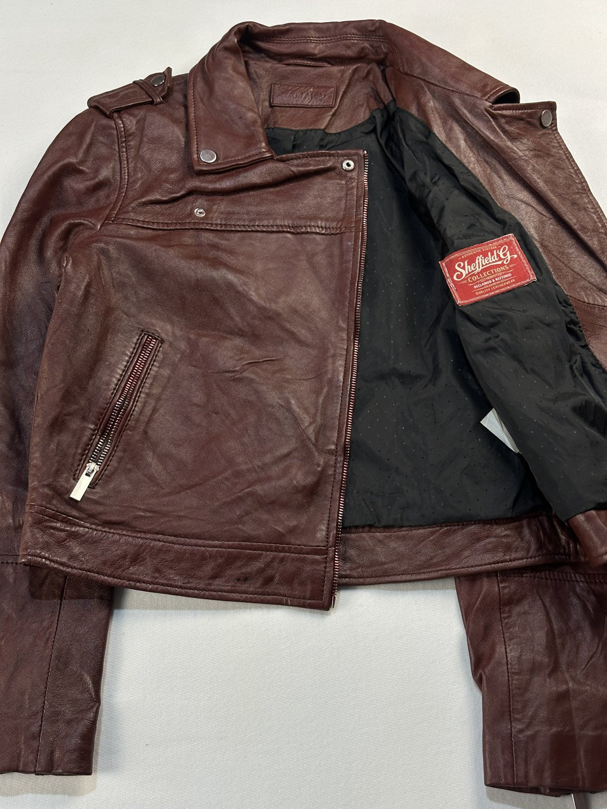 Burgundy biker jacket opened out to show the lining inside