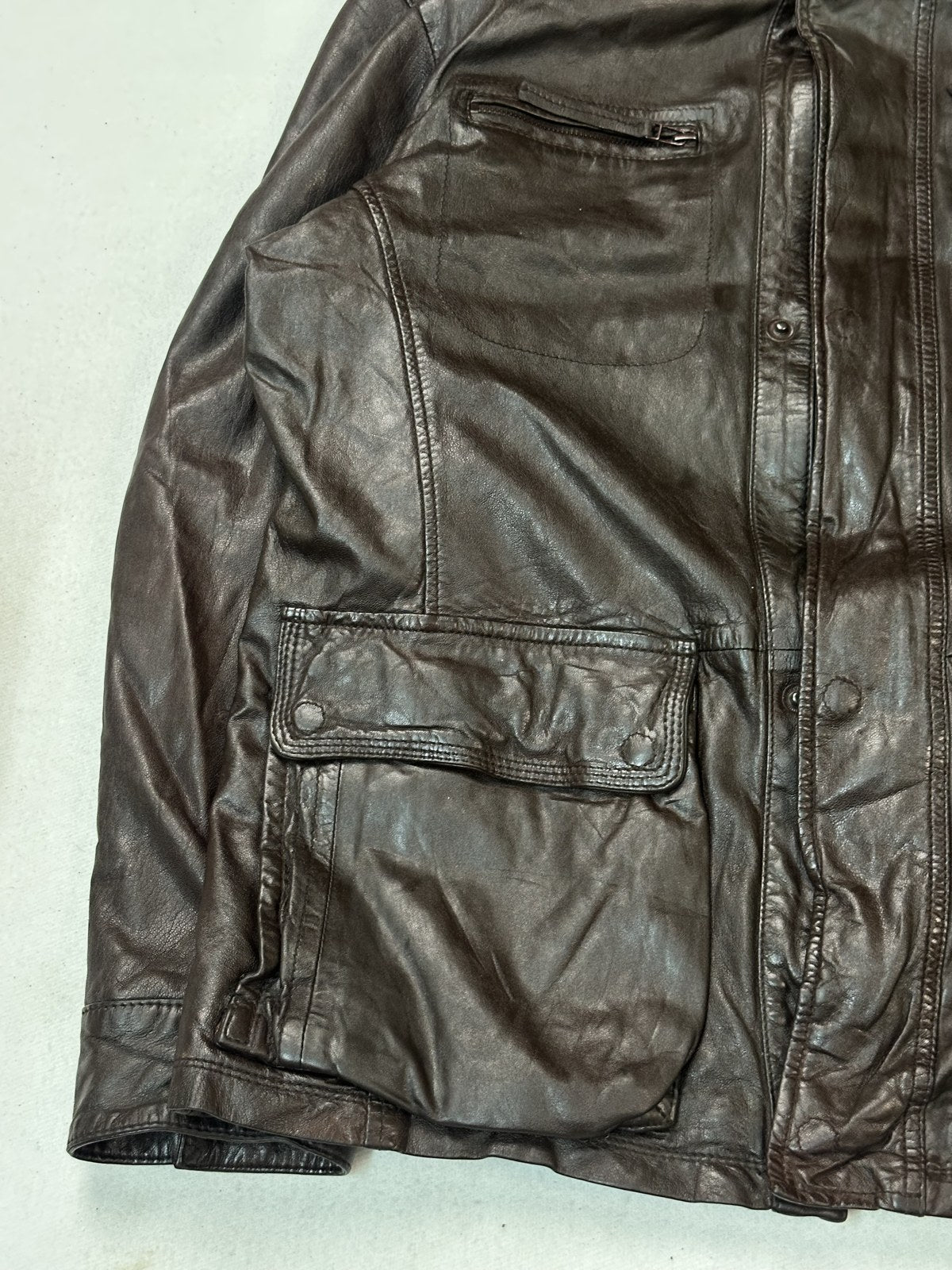 The size XL burgundy utility bomber jacket seen at an angle with one flap pocket in view