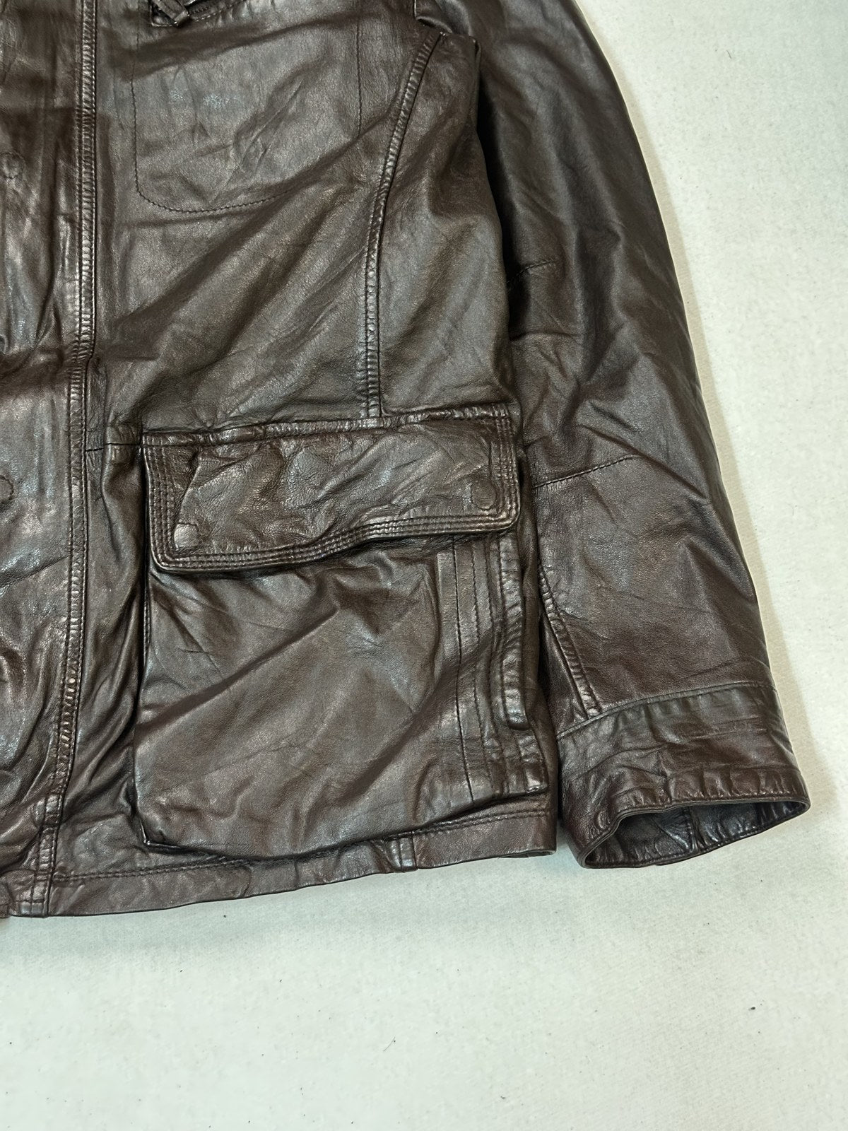 Close detail of one utility pocket and the grain of the burgundy leather