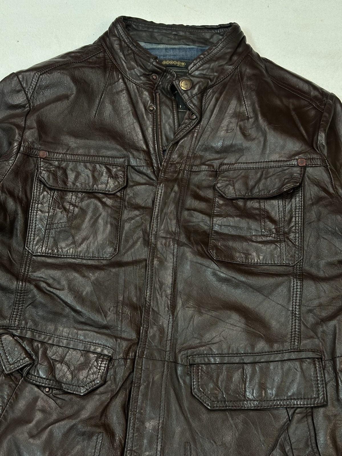 Back panel of the burgundy field pocket jacket laid flat to show the longer hem