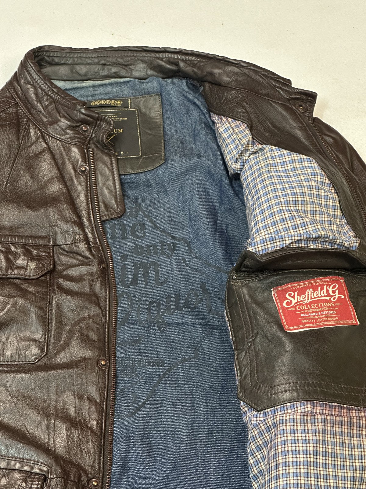 Jacket held open to show the lining of the burgundy leather field pocket bomber