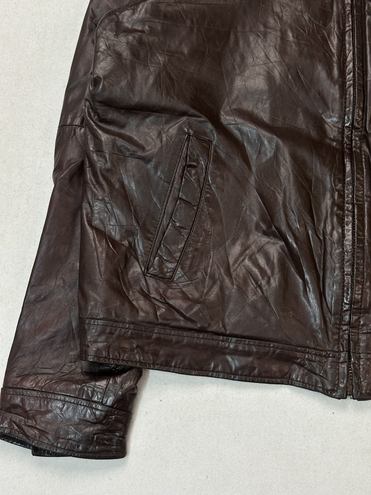 Close view of the wide shirt collar and neck stitching on this vintage burgundy leather jacket