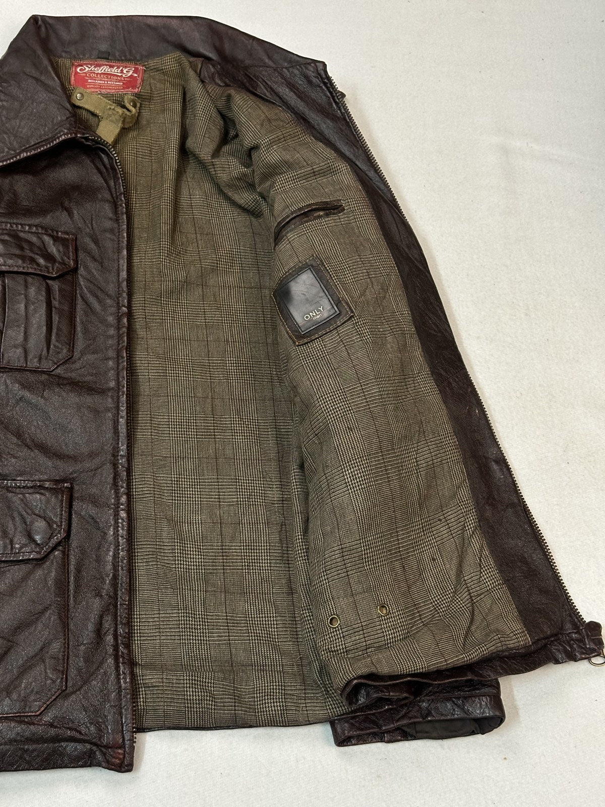 Olive lining inside the size L burgundy leather bomber jacket, front folded back