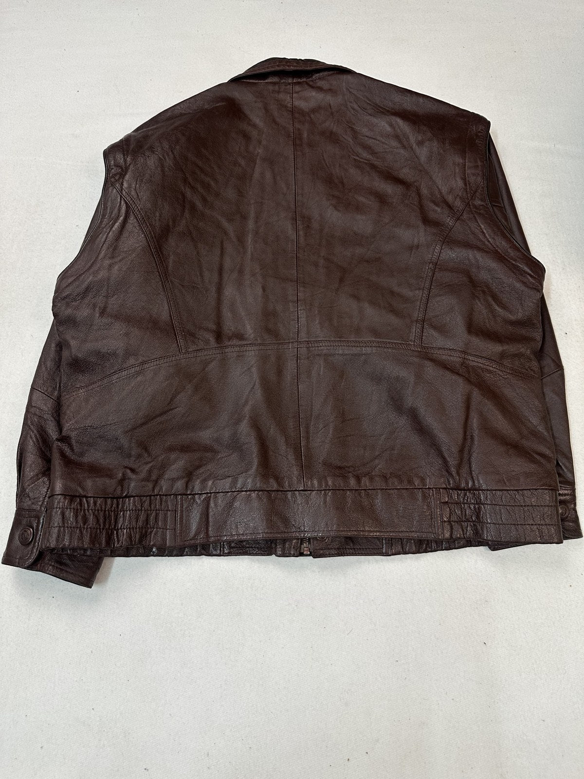 Back of the size XL burgundy bomber jacket showing the straight hem running level across the base