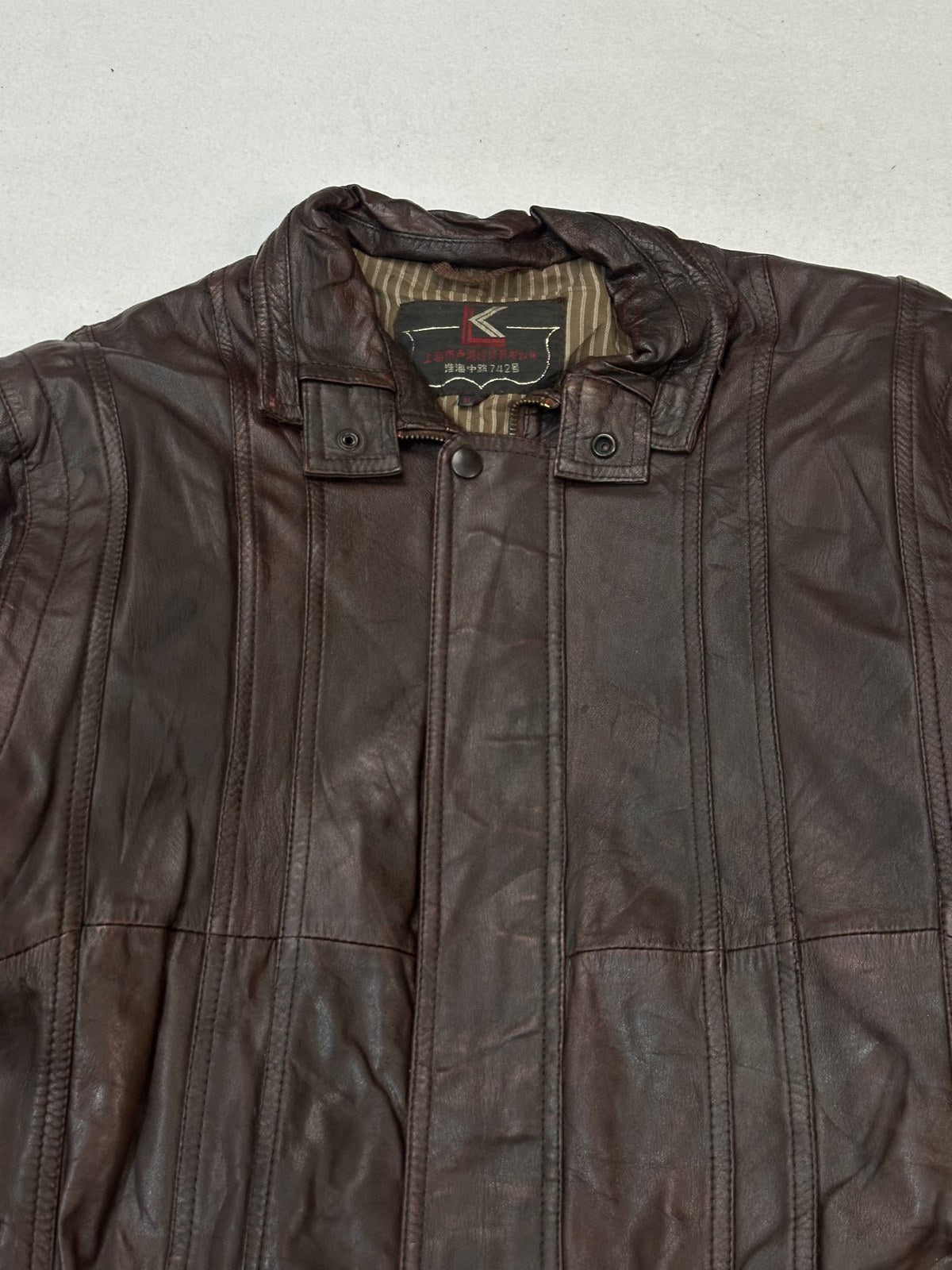 Short stand collar on the size L burgundy twin pocket leather bomber jacket