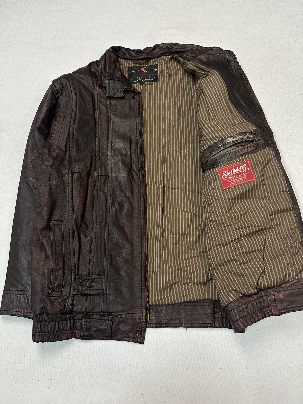Lining shown inside the opened size L burgundy twin pocket bomber jacket