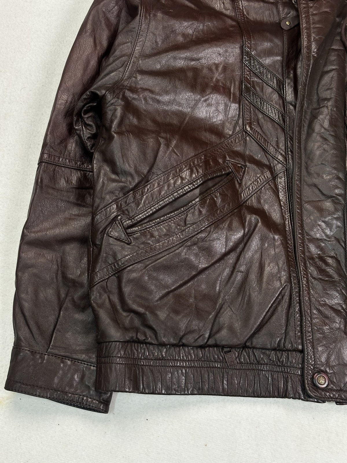Stand collar of the burgundy bomber jacket seen close up from the side