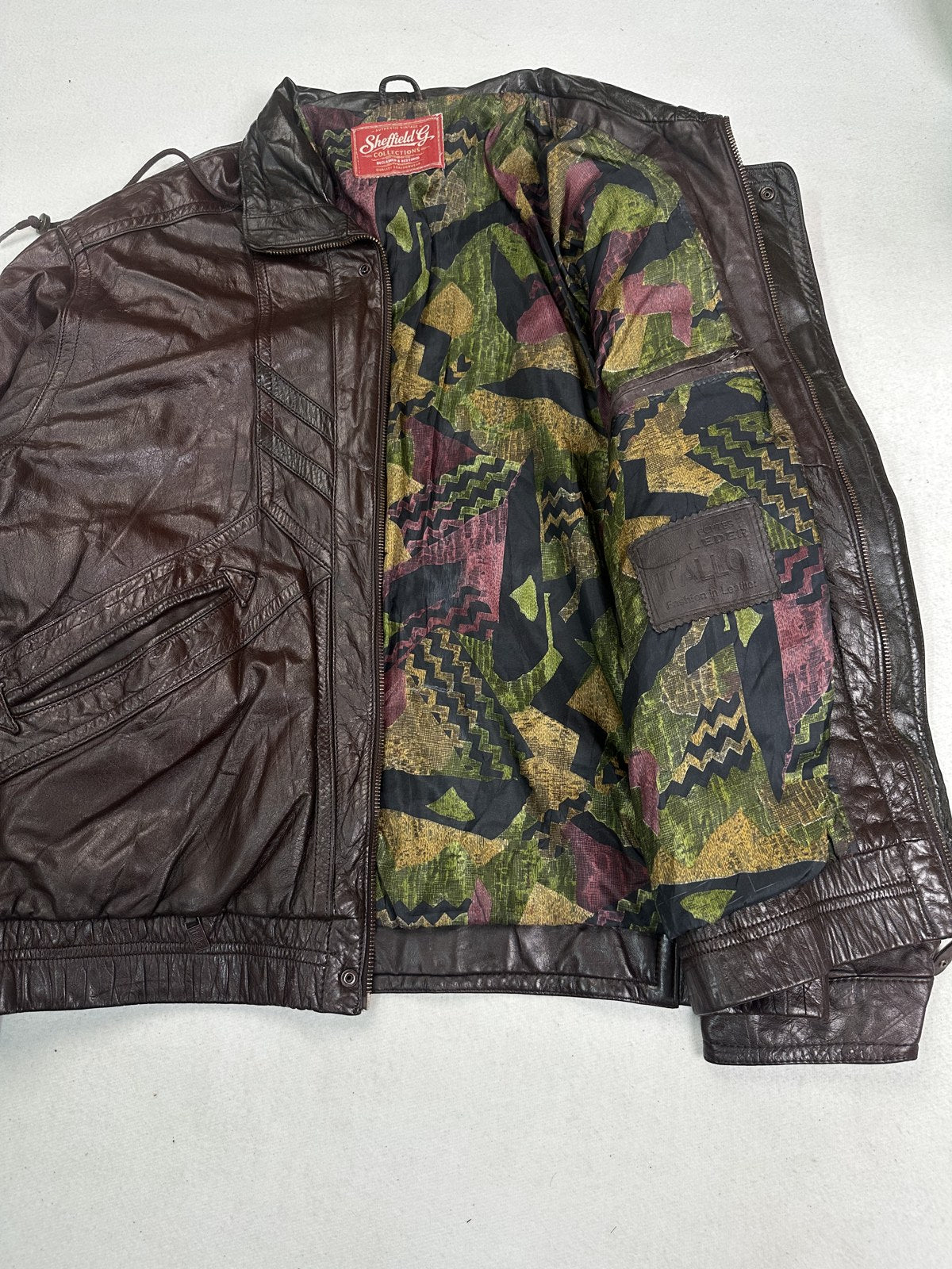 Camouflage print lining revealed inside the burgundy XL bomber jacket