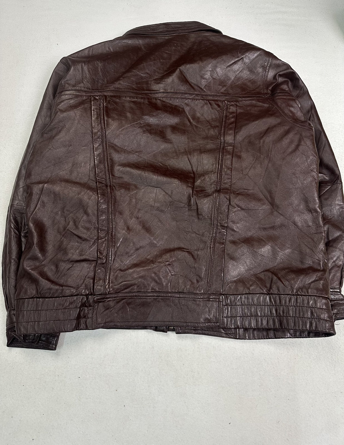Detail of the pocket opening and stitching on the XXL burgundy bomber jacket