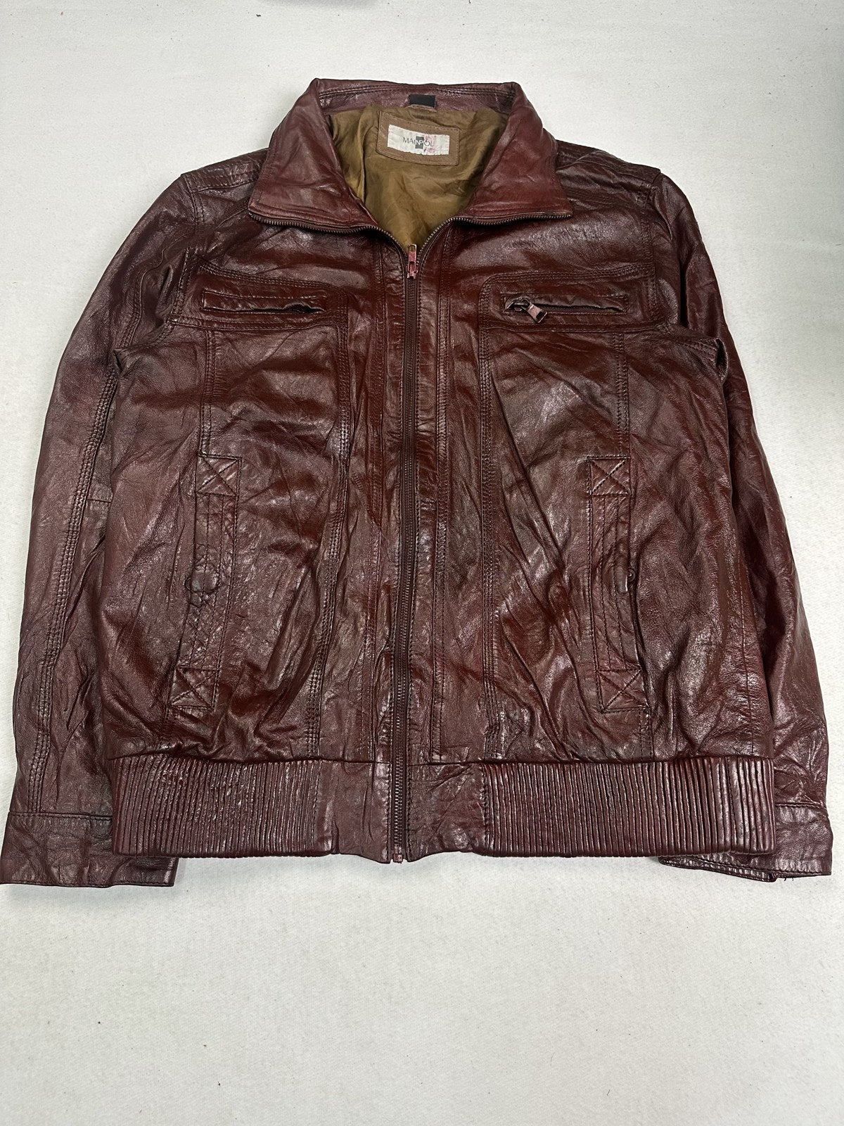Back of the size L burgundy bomber jacket showing the ribbed waist and shoulder seams