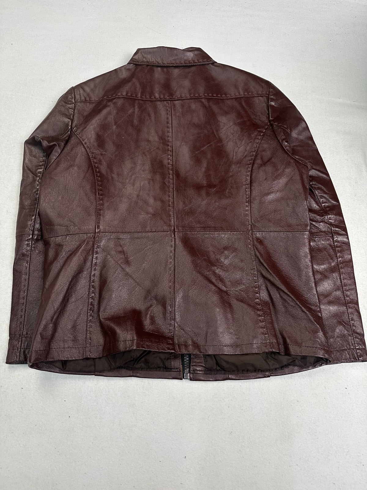 Back panel of the size L burgundy leather bomber jacket, soft shoulder line visible