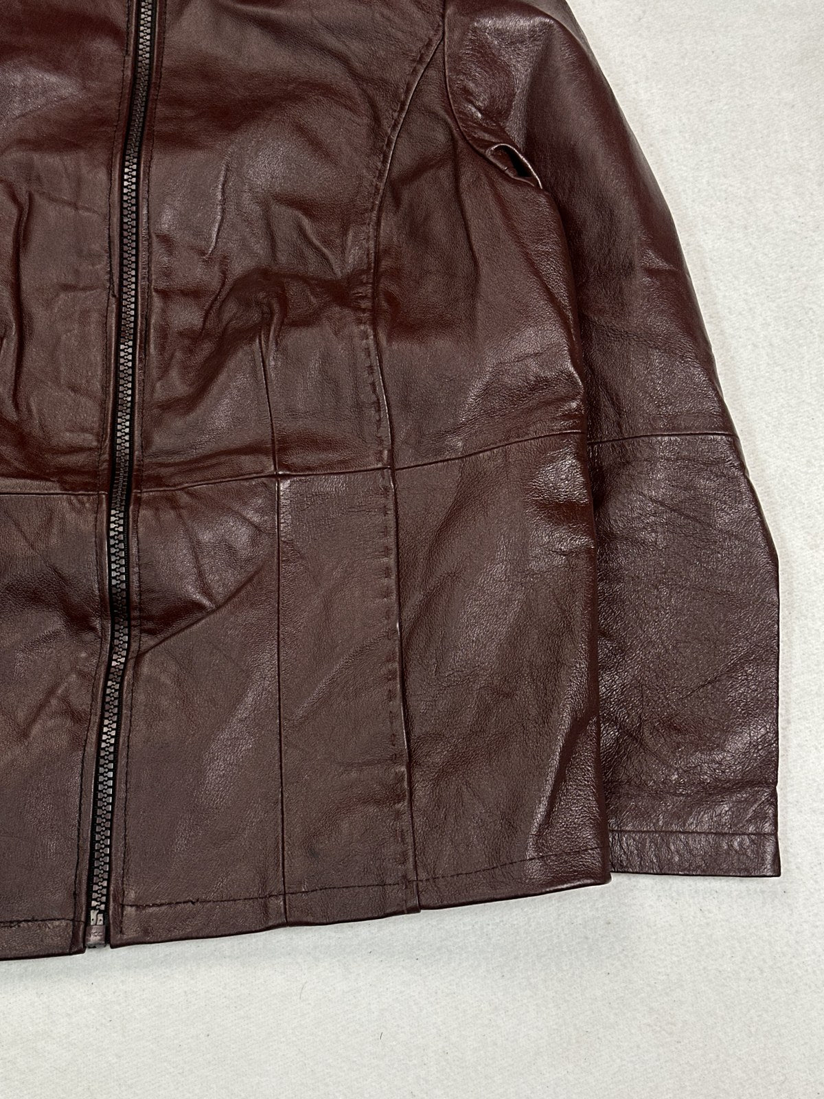 Close view of the cuff and sleeve seam on the burgundy soft shoulder bomber jacket