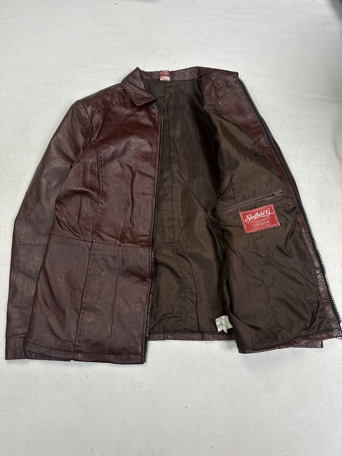 Shirt collar lying flat on the burgundy leather bomber jacket, size XL