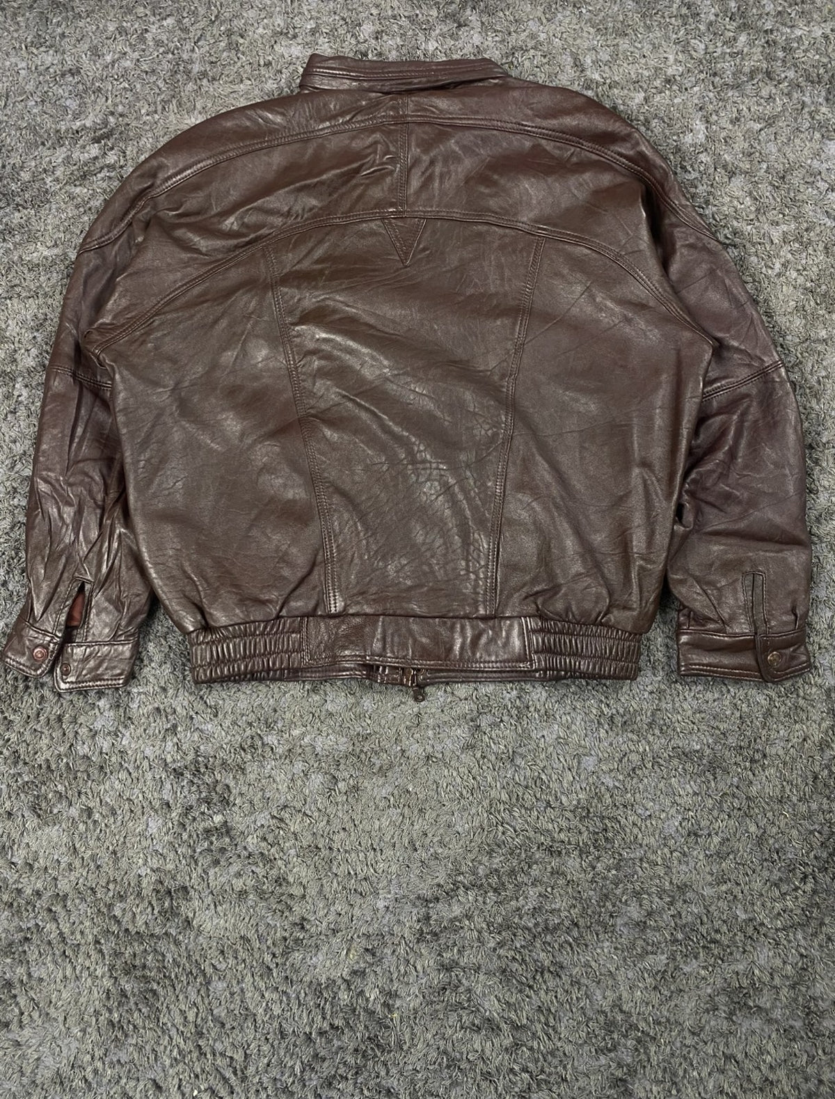 Back of the size XXL burgundy leather bomber jacket, shot flat